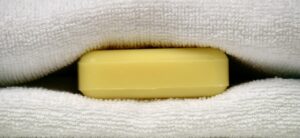 Saponetta posizionata sotto le lenzuola su un letto con lenzuola bianche, simbolo di un trucco per il sonno.