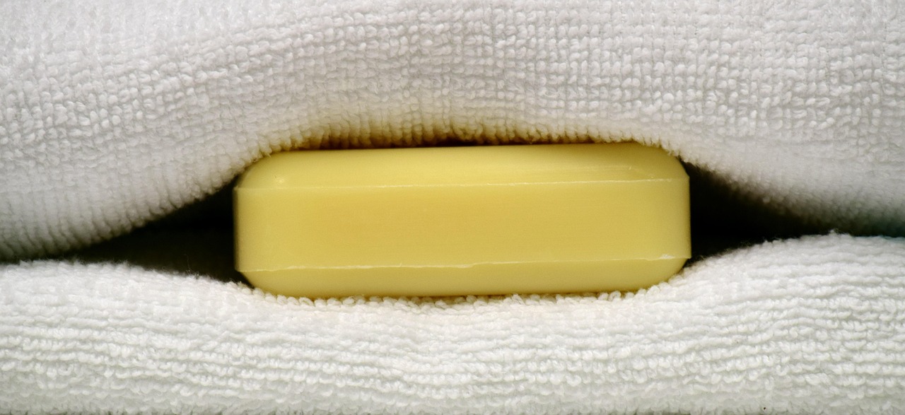 Saponetta posizionata sotto le lenzuola su un letto con lenzuola bianche, simbolo di un trucco per il sonno.