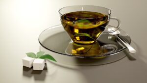 Tazza di tè verde con foglie, evidenziando i rischi per il fegato.