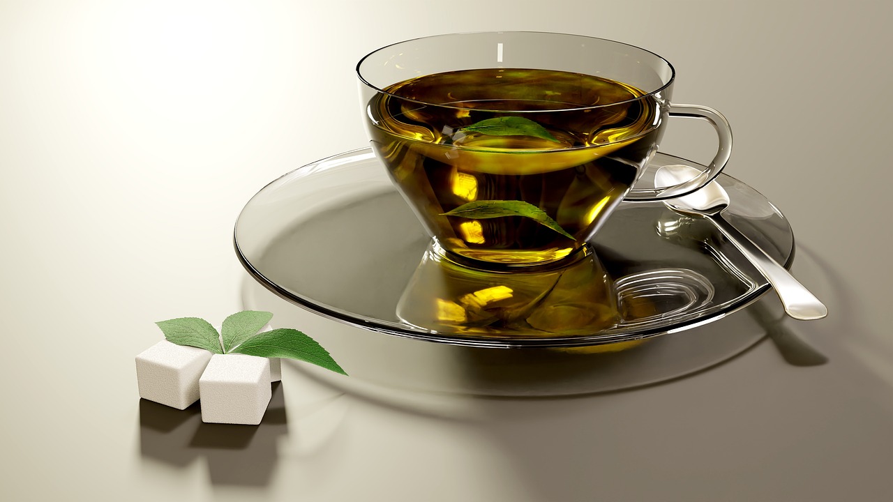 Tazza di tè verde con foglie, evidenziando i rischi per il fegato.